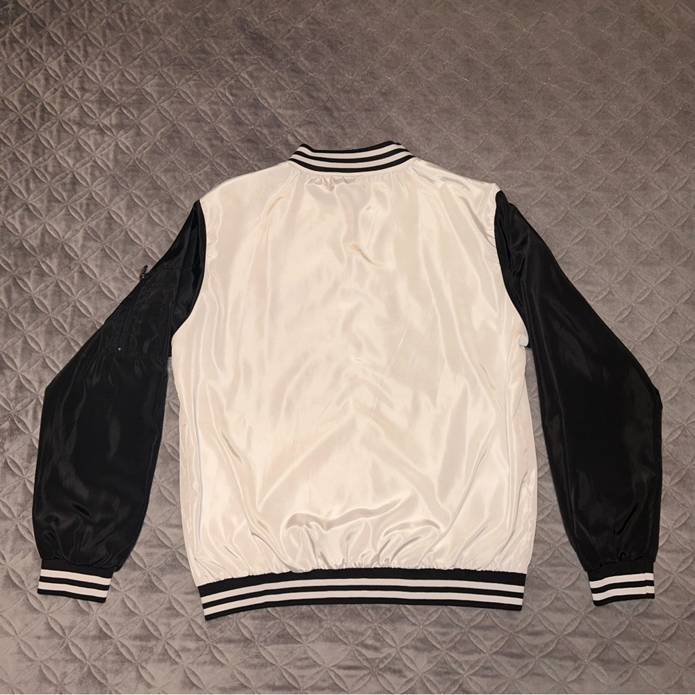 Bomber Jacket that is Zip-Up and has a pocket on the left arm. 100% Polyester.